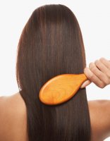 young woman brushing her brunette hair