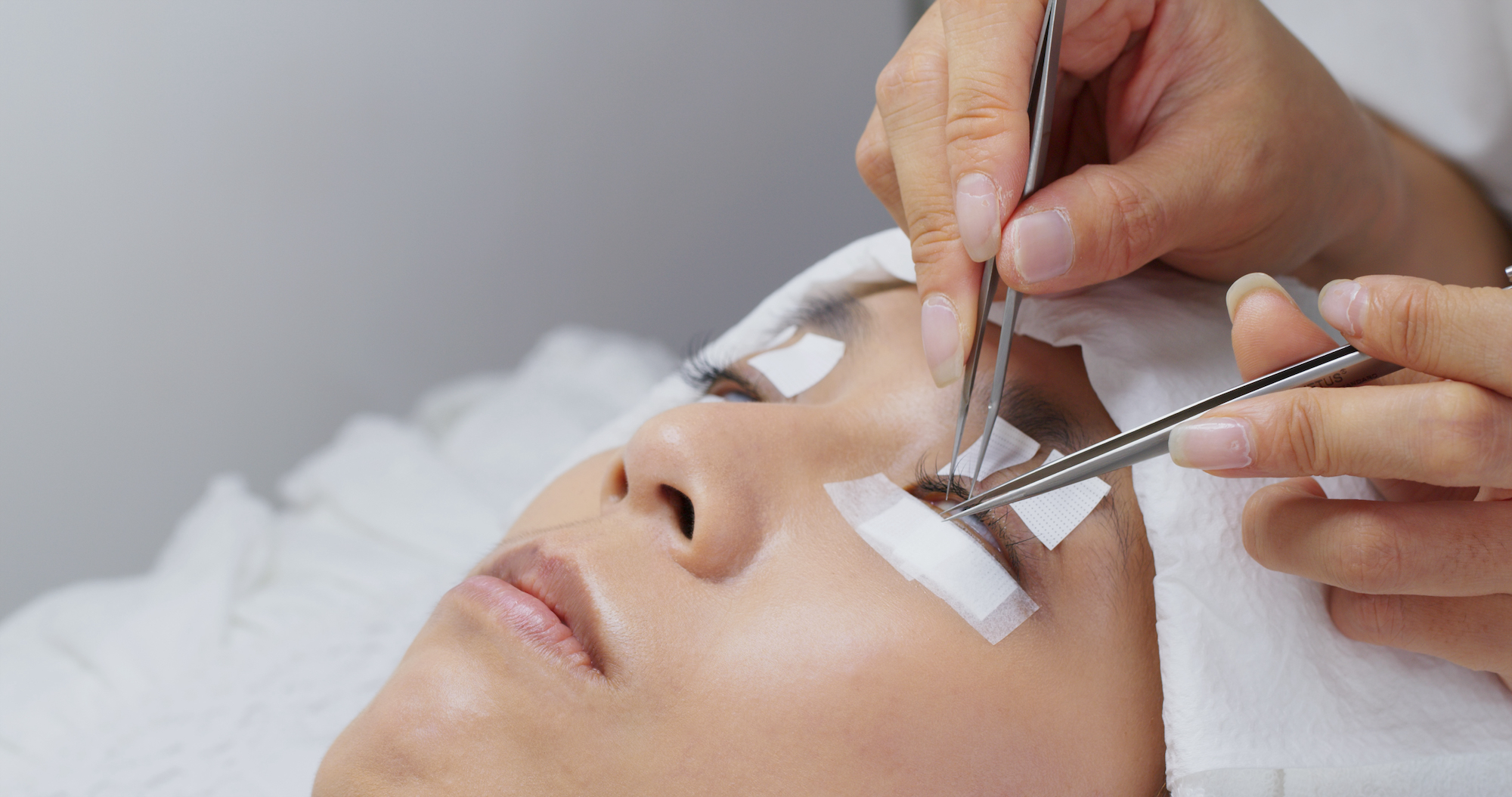 Beautician and young woman in a beauty salon with eye lash extension