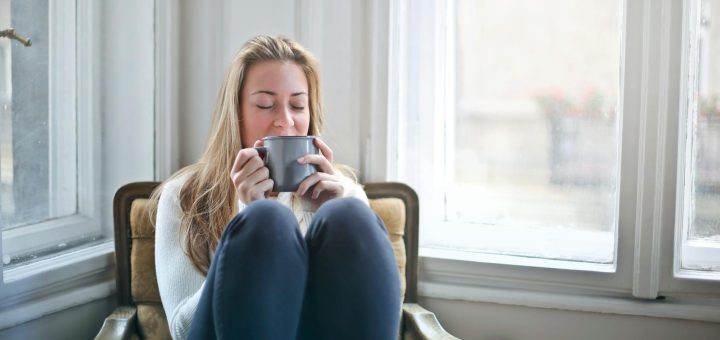 woman holding gray ceramic mug