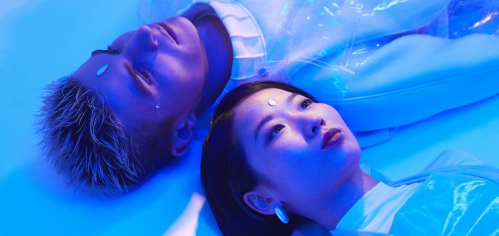 futuristic photo of a young man and woman lying on the floor in blue lighting