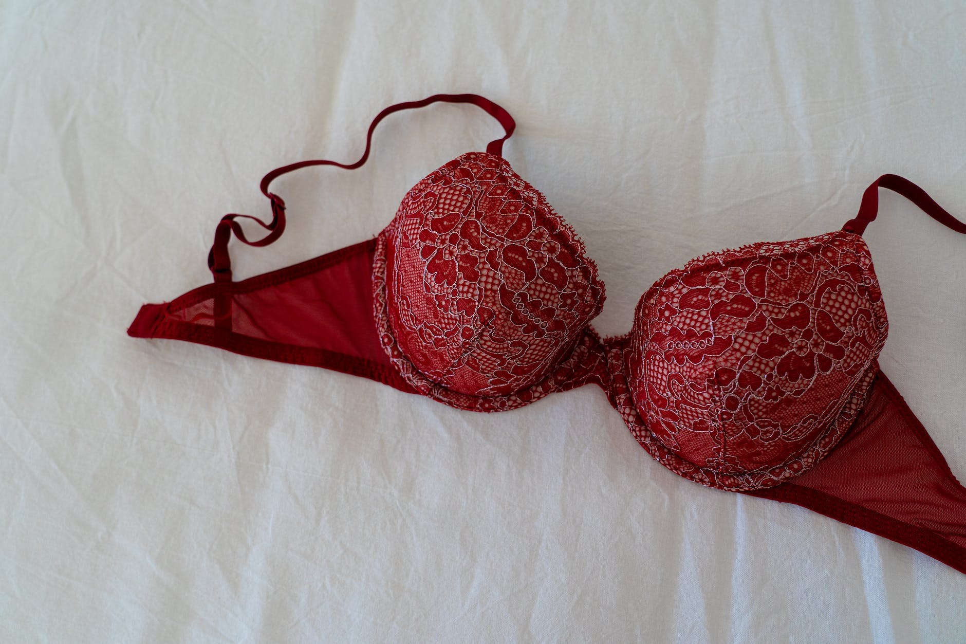 red brassiere on white textile