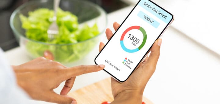 Dieting Concept. Unrecognizable woman eating vegetable salad and counting daily calories with app on smartphone, checking calorie chart in mobile application, creative collage for weightloss, closeup
